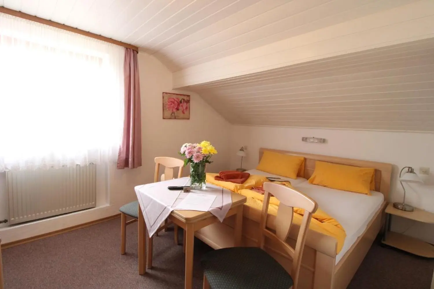 Zur Auszeit - Innenansicht eines Schlafzimmers mit kleinem Esstisch für zwei Personen